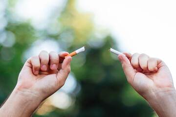 World No Smoking Day. The fight against nicotine addiction. The guy breaks a cigarette. Male hand...
