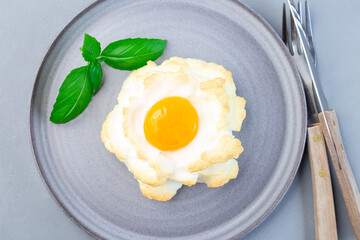 Trendy cloud or fluffy egg dish on gray plate, horizontal, top view
