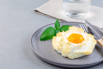 Oven baked cloud or fluffy egg dish on  gray plate, horizontal, copy space