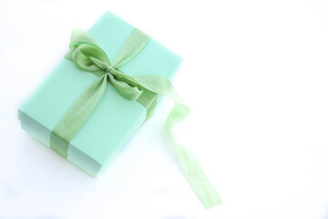 Girl holds a gift box and unties the bow. a girl opens a gift box. Gift box on a red background. Girl unties the tape from the box.
