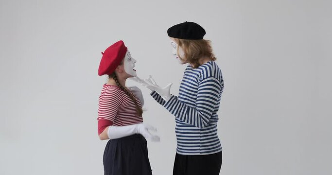 Profile of mime artist couple arguing and fighting over white background