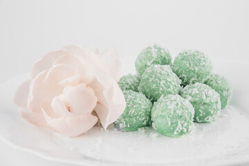 cookies with almonds, cream and coconut shavings on a plate on a white background