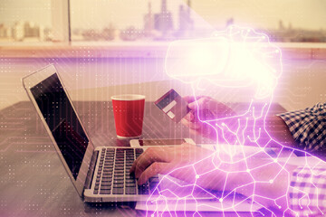 Double exposure of man hands holding a credit card and human in vr glasses drawing. Virtual reality and E-commerce concept.