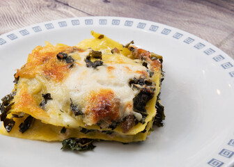 Lasagna with black cabbage, mozzarella and sausage.