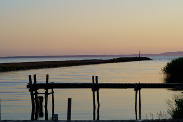 Fototapeta na wymiar Coastal summer sunset with pier and wooden jetty in Skalderviken, Sweden 