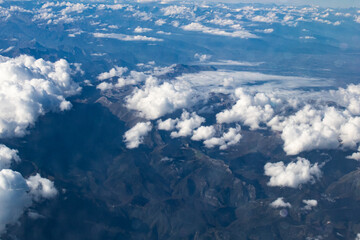 imagen aérea de las montañas con nubes blancas y esponjosas dispersas en la parte superior de estos