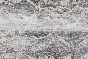Delicate lace textured material on distressed wood background