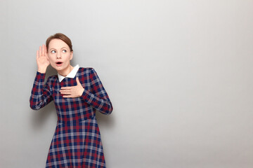 Portrait of curious girl placing hand near ear and eavesdropping