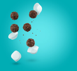 Brigadeiro (Brigadeiro), a Brazilian chocolate candy. Traditional Brazilian handmade chocolate candy. Falling in motion on blue background