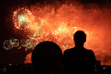 Silhouette of a man watching the fireworks show (selective focus)
