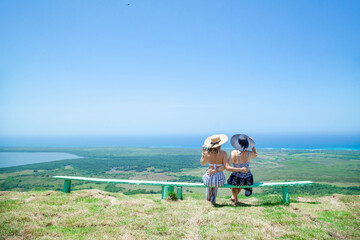 Woman sitting on the bench with green mountains, ocean sea caribbean tropical landscape and horizon...