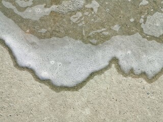 Water stains and white bubbles on the concrete floor.