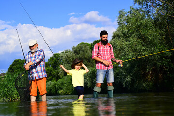 Grandfather, father and son are fly fishing on river. Anglers. Family bonding.