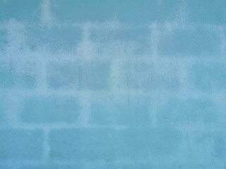 The old house's walls are made of concrete blocks painted in blue. The painted color began to fade.