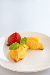 Close up a group of homemade Choux (Eclair) in a white dish on a white table