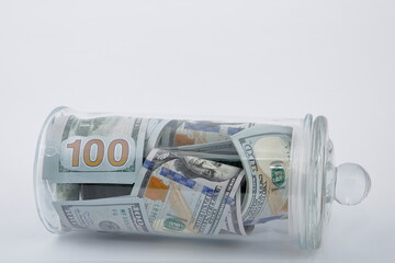 On a White Background, Composition of american dollars (USD) In glass jar.