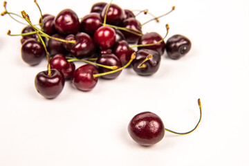 Handful of a dark red cherry on a white background close-up