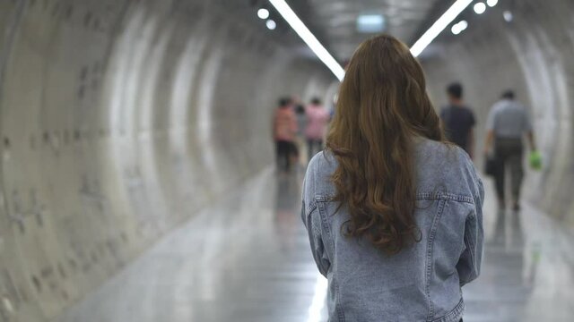 HD Slow Motion Smiling Young Beautiful Long Hair Asian Woman In Blue Jeans Jacket Walking Forward With Crowd People In Subway Station. City Lifestyle Concept.