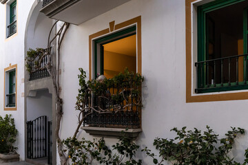 Fototapeta na wymiar old woman relax on balcony with flowers at evening, gran canaria, spain