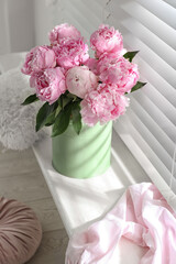 Bouquet of beautiful peonies on window sill