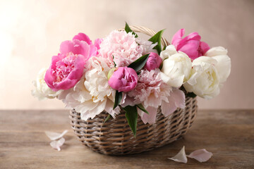 Fototapeta na wymiar Beautiful peony bouquet in wicker basket on wooden table