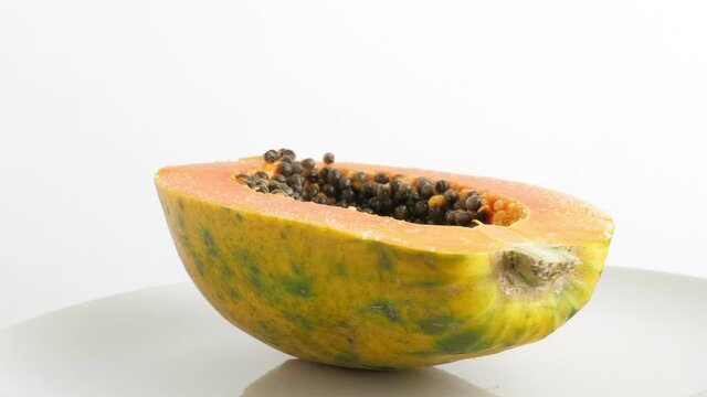 Ripe half cut papaya fruit. Rotate on white background