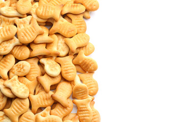 Delicious crispy goldfish crackers on white background, top view