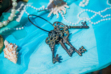 Forged vintage bronze decorative big keys laying on blue background.A bunch of keys, wedding event decoration. 