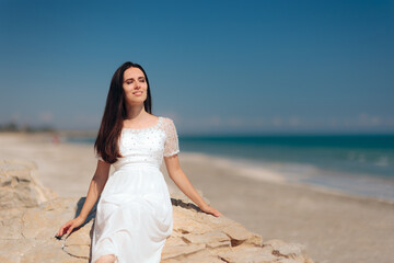 Fototapeta na wymiar Woman in Wedding Dress Sunbathing by the Beach