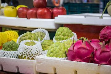 バンレイシやドラゴンフルーツなど色鮮やかなトロピカルフルーツが並ぶ南国の市場の青果店