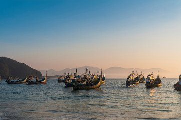 fishing boats on the papuma beach at sunset