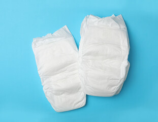 Baby diapers on light blue background, flat lay