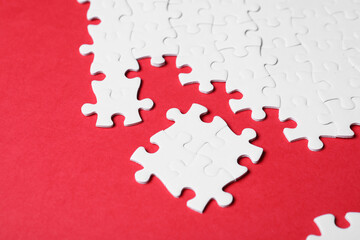 Blank white puzzle pieces on red background