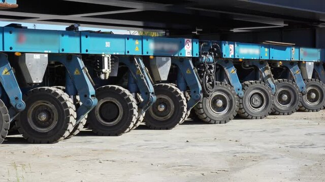 Heavy industrial self propelled modular trailer moving a train railway. Giant civil construction being transported by autonomous machinery. 