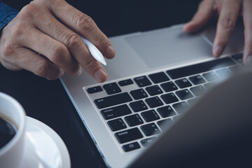 Fototapeta na wymiar Close up of man hand typing on laptop computer keyboard while online working 