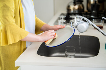 お皿を洗う女性の手元