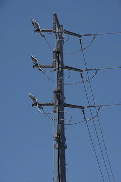 Top section of a new and modern electricity distribution pylon and its power lines