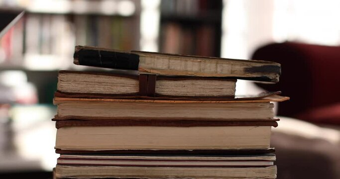 Someone takes books from an old pile of notebooks