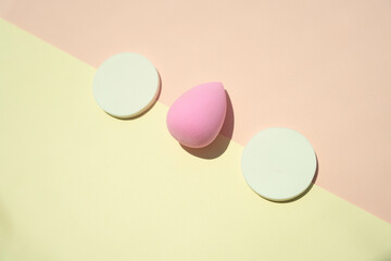 Make up tools cosmetics. Powder puff isolate on two tone colour yellow and pink. Funny face.