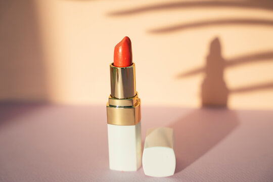 Close Up Of Orange Red Lipstick In Retro Vintage Background.