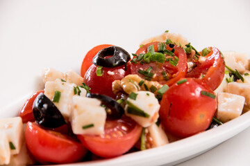A plate of tomato and cheese salad on a white background