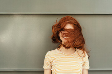 Happy woman with her red hair covering her face