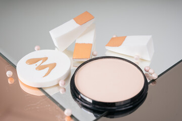 Variety of makeups products set. Cosmetics product and beige skin tone powder puff.