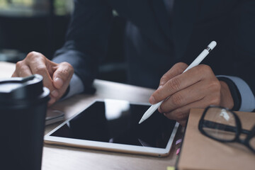 Businessman using stylus pen signing on digital document or business contract on digital tablet in office