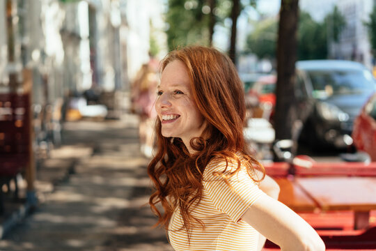 Smiling happy young woman outdoors in town