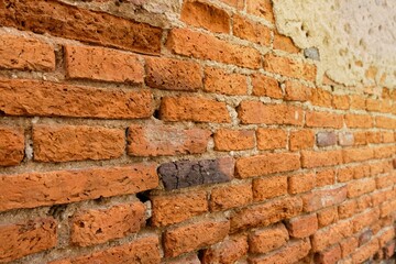 The cement walls are old and deteriorated over time. The walls were so cracked that they could see bricks made of clay.