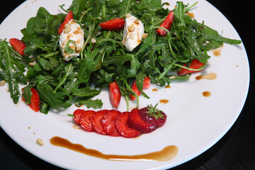 Salad with arugula, cream cheese and strawberries. Salad with arugula and strawberries. Rucola and strawberries.