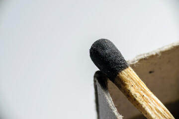 Isolated match stick kept over the edge of a matchbox in a white background. Space for text in left