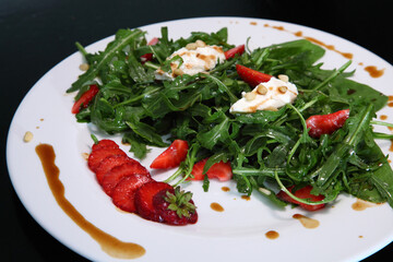 Salad with arugula, cream cheese and strawberries. Salad with arugula and strawberries. Rucola and strawberries.