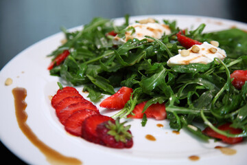 Salad with arugula, cream cheese and strawberries. Salad with arugula and strawberries. Rucola and strawberries.